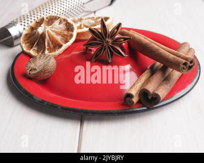Verschiedene weihnachtliche Gewürze auf einem Holztisch, saisonale Speisen oder Zutaten Konzept Stockfoto