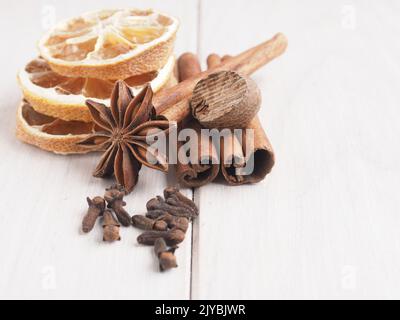 Verschiedene weihnachtliche Gewürze auf einem Holztisch, saisonale Speisen oder Zutaten Konzept Stockfoto