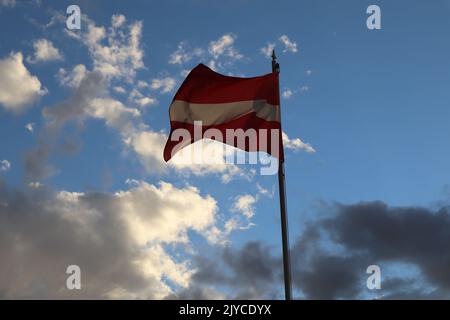 Lettische Fahne winken in den Himmel Stockfoto