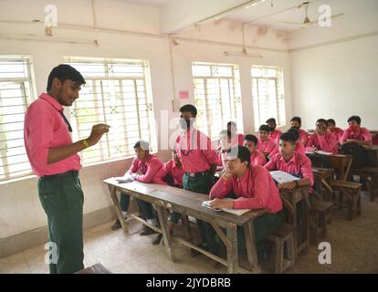 Ein älterer Schüler nimmt im Vorfeld des „Teachers Day“ in Agartala an den Kursen der Juniorschüler der höheren Sekundarschule Netaji Subhas Vidyaniketan Teil. Der Tag der Lehrer wird am 5.. September begangen, um Lehrer für ihren Beitrag in der Gesellschaft zu würdigen. Tripura, Indien. Stockfoto