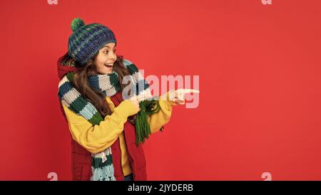 ausdruck positiver Emotionen. Wintermode. Zeigefinger auf Kopierraum. Stockfoto