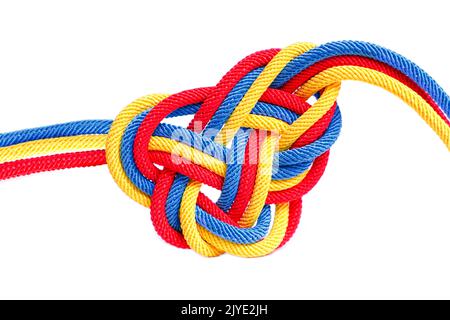 Herzförmiger keltischer Knoten aus geflochtenen Schnüren, der die Farben der Nationalflagge Rumäniens auf weißem Hintergrund malte. Kreative Einheit, Glaube und Pro Stockfoto