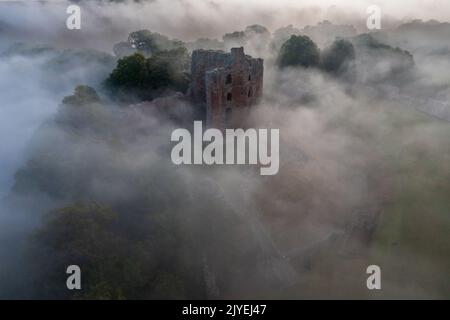 Norham Castle steigt durch den frühen Morgennebel auf Stockfoto