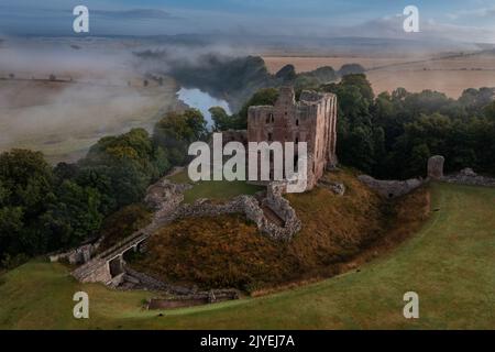 Norham Castle steigt durch den frühen Morgennebel auf Stockfoto