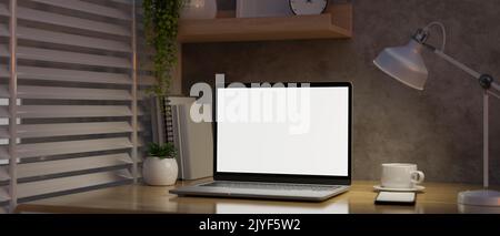 Modernes minimalistisches Loft-Arbeitsplatzdesign mit Notebook-Laptop-Modell mit weißem Bildschirm, Tischlampe und Zubehör auf Holztisch über Zement-Loft-Wand. Close-U Stockfoto