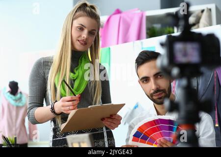 Zwei junge Blogger-Designer senden auf professioneller Kamera, sprechen über Tipps und chatten mit Abonnenten Stockfoto