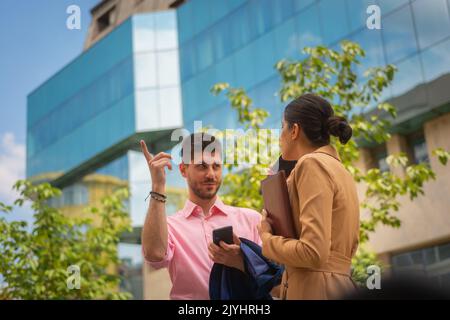 Ein junger Geschäftsmann erklärt seiner Kollegin seine Ideen Stockfoto