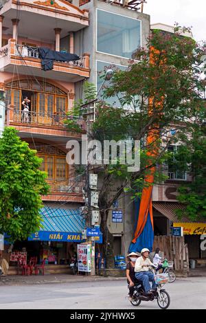 Motorrad mit Beifahrer vor typisch vietnamesischem Stadthaus, Hai Phong, Vietnam Stockfoto