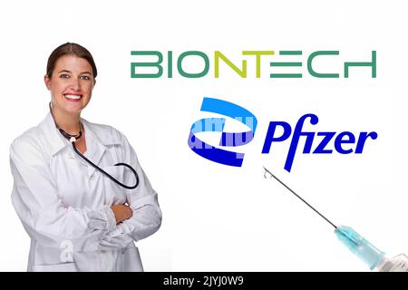 Ärztin mit Stethoskop und Logo von BioNTech und Pfizer, MR=Yes Stockfoto