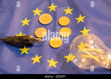 Vaduz, Liechtenstein, 6. September 2022 Europaflagge mit einigen Geldmünzen und einer abgetrennten Glühbirne darauf Stockfoto