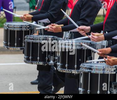 Bass-Teil einer marschierenden Band-Drum-Line, die sich für eine Parade aufwärmt Stockfoto