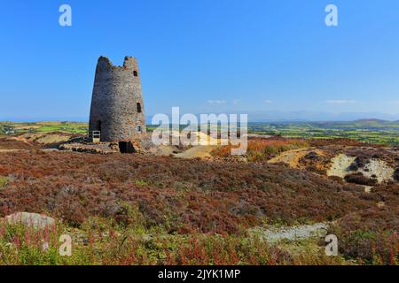 Stillgelegte Windmühle am Parys Mountain mit Snowdonia in der Ferne. Anglesey, Nordwales, Großbritannien. Stockfoto