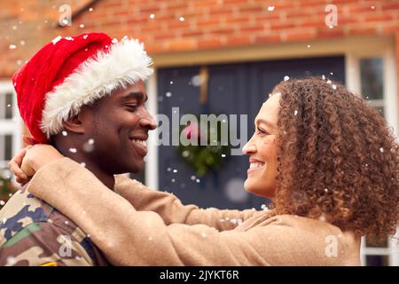 American Soldier In Uniform Trägt Weihnachtsmütze Rückkehr Nach Hause Am Weihnachtsurlaub Umarmende Frau Stockfoto