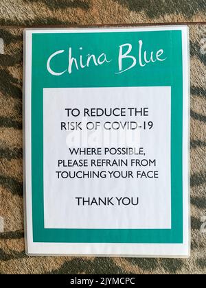 Totnes, South Devon, Großbritannien. 24.. Juli 2022. Ein Covid-19-Schild am China Blue-Laden und Restaurant in Totnes, das die Kunden daran erinnert, Covid-19-Sicherheitsvorkehrungen zu treffen. Quelle: Maureen McLean/Alamy Stockfoto