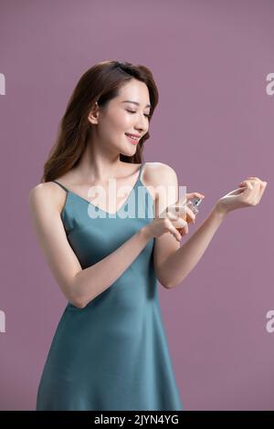 Schöne junge chinesische Frau mit Parfüm Stockfoto