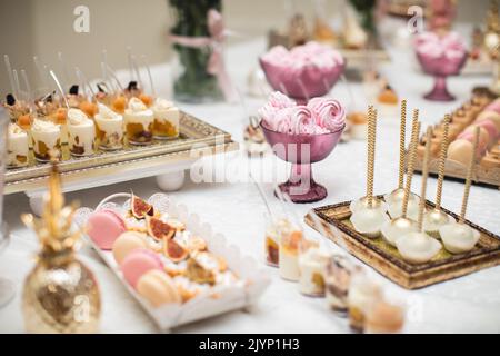 Wunderschön dekorierter Tisch mit Süßigkeitenbar Stockfoto