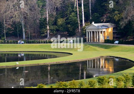 Der Tempel der Frömmigkeit spiegelt sich in den Gewässern von Moon & Crescent Ponds in Fountains Abbey und Studley Royal Water Garden, North Yorkshire, England, Großbritannien, wider. Stockfoto