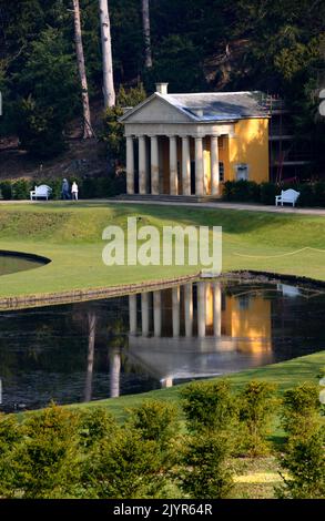 Der Tempel der Frömmigkeit spiegelt sich in den Gewässern von Moon & Crescent Ponds in Fountains Abbey und Studley Royal Water Garden, North Yorkshire, England, Großbritannien, wider. Stockfoto