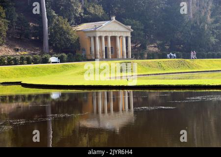 Der Tempel der Frömmigkeit spiegelt sich in den Gewässern von Moon & Crescent Ponds in Fountains Abbey und Studley Royal Water Garden, North Yorkshire, England, Großbritannien, wider. Stockfoto