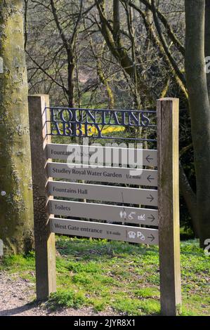 Holz- und Metallschilder auf dem Gelände der Ruinen von Fountains Abbey Zisterzienserkloster, North Yorkshire, England, Großbritannien. Stockfoto