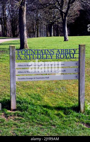 Holz- und Metallschilder auf dem Gelände der Ruinen von Fountains Abbey Zisterzienserkloster, North Yorkshire, England, Großbritannien. Stockfoto