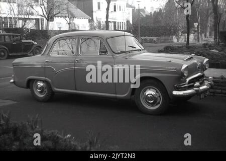 1950s, historisch, ein Auto der Ära, ein Austin Cambridge, ein A55, geparkt auf einer Auffahrt, abseits einer Vorstadtstraße, England, Großbritannien. Ein Vorkriegsauto steht auf der Straße dahinter. Die Austin Cambridge wurde in Cowley, Oxford, England, über mehrere Generationen und in verschiedenen Modellen, von 1954 bis 1971, Stockfoto