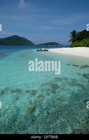 Indonesien Anambas-Inseln - idyllische Strandlandschaft mit Palmen und vertikalen Booten Stockfoto