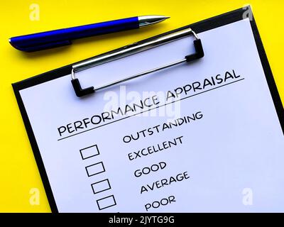 Draufsicht der Checkliste für die Leistungsbewertung auf der Clipboard mit gelbem Hintergrund. Konzept der Leistungsbeurteilung. Stockfoto