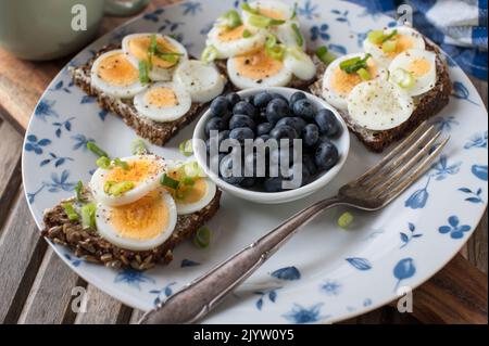 Fitness-Frühstücksteller mit Ei-Sandwich und frischen Beeren Stockfoto