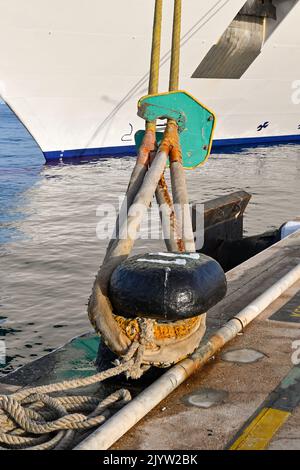 Nahaufnahme der Anlegestellen eines Kreuzfahrtschiffs, das um einen Anlegepunkt in einem kommerziellen Dock geschleift ist. Keine Personen. Stockfoto