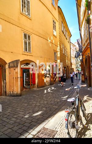 Prag, Tschechien, 29. August 2022: Geparktes Fahrrad in einer engen, pittoresken Gasse in der Prager Altstadt, Fahrradtour durch Prag und Tschechien Stockfoto