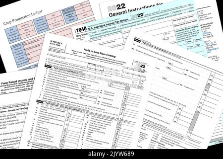 2022 IRS 1040 & Agrarsteuerformulare mit einer simulierten Ernteproduktionsseite auf einem schwarzen Desktop. Stockfoto