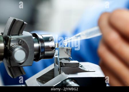 Nahaufnahme ein Wissenschaftler, der Glasmesser mit Wasser und Wasserboot, das auf einem Ultramikrotom montiert ist, um Schnitte für das Elektronenmikroskop zu machen Stockfoto