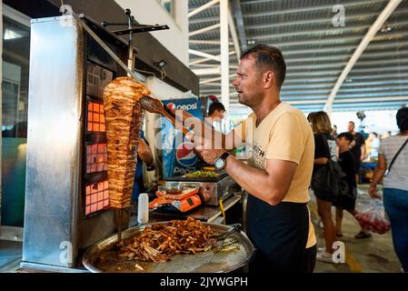 ANTALYA, TÜRKEI : Ein Koch schneidet traditionellen türkischen Döner Kebab in einem Street-Food-Shop auf dem Taksim-Platz am - 5. September 2022 Stockfoto