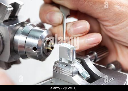 Nahaufnahme einer Wissenschaftlerin, die eine Probe auf ein Transmissions-Elektronenmikroskopieraster platziert Stockfoto