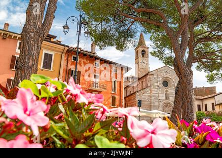 Esplanade von Maderno mit Blumen und alter Kirche am Gardasee in Norditalien Stockfoto