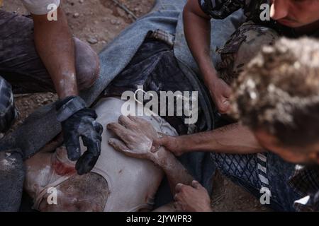 Hafsarjah, Syrien. 08. September 2022. Syrer transportieren die Leiche eines Mannes, der infolge eines russischen Luftangriffs auf das Dorf Hafsarjah in der westlichen Landschaft des Gouvernements Idlib getötet wurde. Mindestens sieben Menschen wurden bei den Streiks, die auf einen Steinbruch und ein Haus abzielten, getötet und 15 weitere verletzt, teilte eine Überwachungsgruppe mit. Quelle: Anas Alkharboutli/dpa/Alamy Live News Stockfoto