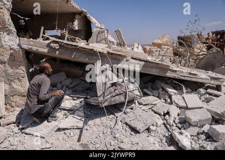 Hafsarjah, Syrien. 08. September 2022. Unter den Trümmern eines Gebäudes, das von einem russischen Luftangriff auf das Dorf Hafsarjah in der westlichen Landschaft des Gouvernements Idlib anvisiert wurde, suchen Menschen nach Überlebenden. Mindestens sieben Menschen wurden bei den Streiks, die auf einen Steinbruch und ein Haus abzielten, getötet und 15 weitere verletzt, teilte eine Überwachungsgruppe mit. Quelle: Anas Alkharboutli/dpa/Alamy Live News Stockfoto