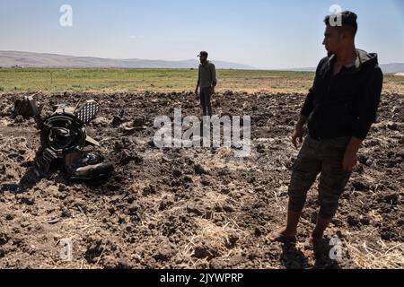 Hafsarjah, Syrien. 08. September 2022. Nach einem russischen Luftangriff in der westlichen Landschaft des Regierungsbezirks Idlib inspizieren Menschen Überreste einer Clusterrakete. Mindestens sieben Menschen wurden bei den Streiks, die auf einen Steinbruch und ein Haus abzielten, getötet und 15 weitere verletzt, teilte eine Überwachungsgruppe mit. Quelle: Anas Alkharboutli/dpa/Alamy Live News Stockfoto