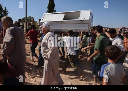 Hafsarjah, Syrien. 08. September 2022. Syrer tragen den Sarg eines Mannes, der infolge eines russischen Luftangriffs auf das Dorf Hafsarjah im westlichen Landgebiet des Gouvernements Idlib getötet wurde. Mindestens sieben Menschen wurden bei den Streiks, die auf einen Steinbruch und ein Haus abzielten, getötet und 15 weitere verletzt, teilte eine Überwachungsgruppe mit. Quelle: Anas Alkharboutli/dpa/Alamy Live News Stockfoto