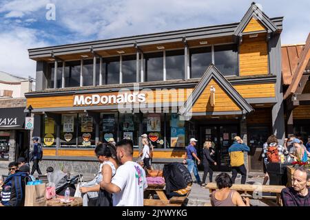 Banff, Alberta, Kanada - 6. Juli 2022: Touristen genießen das wunderschöne Wetter, während sie draußen in Banff, Kanada, bei McDonalds essen Stockfoto