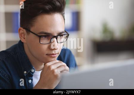 Denken Sie Über Eine Lösung Nach. Junger Geschäftsmann In Einer Brille, Der Auf Den Computerbildschirm Schaut, Nahaufnahme Stockfoto