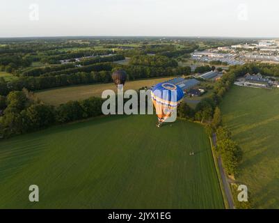 Barneveld, 3.. August 2022, Niederlande. Ballonfahrten in Bas. Ballonsegler Landung in Bauernhof Grasland Feld. Heißluftballonflugzeug Stockfoto