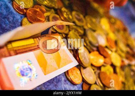 Gesparte Euromünzen und Scheine auf blauem Hintergrund in Bremerhaven Deutschland. Stockfoto