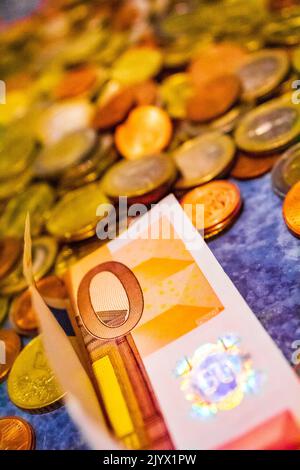 Gesparte Euromünzen und Scheine auf blauem Hintergrund in Bremerhaven Deutschland. Stockfoto