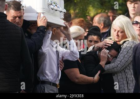 Margaret Cash McDonagh, die Mutter von Lisa Cash, 18, und ihren achtjährigen Zwillingsgeschwistern Christy und Chelsea Cawley, wird getröstet, als die Särge ihrer Kinder vor ihrem Umzugsdienst in der St. Aidan's Church, Brookfield, Tallaght, ankommen. Bilddatum: Donnerstag, 8. September 2022. Stockfoto