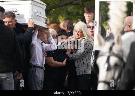 Margaret Cash McDonagh, die Mutter von Lisa Cash, 18, und ihren achtjährigen Zwillingsgeschwistern Christy und Chelsea Cawley, wird getröstet, als die Särge ihrer Kinder vor ihrem Umzugsdienst in der St. Aidan's Church, Brookfield, Tallaght, ankommen. Bilddatum: Donnerstag, 8. September 2022. Stockfoto