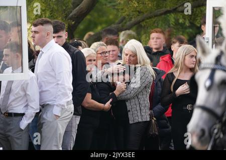 Margaret Cash McDonagh, die Mutter von Lisa Cash, 18, und ihren achtjährigen Zwillingsgeschwistern Christy und Chelsea Cawley, wird getröstet, als die Särge ihrer Kinder vor ihrem Umzugsdienst in der St. Aidan's Church, Brookfield, Tallaght, ankommen. Bilddatum: Donnerstag, 8. September 2022. Stockfoto