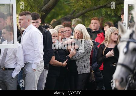 Margaret Cash McDonagh, die Mutter von Lisa Cash, 18, und ihren achtjährigen Zwillingsgeschwistern Christy und Chelsea Cawley, wird getröstet, als die Särge ihrer Kinder vor ihrem Umzugsdienst in der St. Aidan's Church, Brookfield, Tallaght, ankommen. Bilddatum: Donnerstag, 8. September 2022. Stockfoto