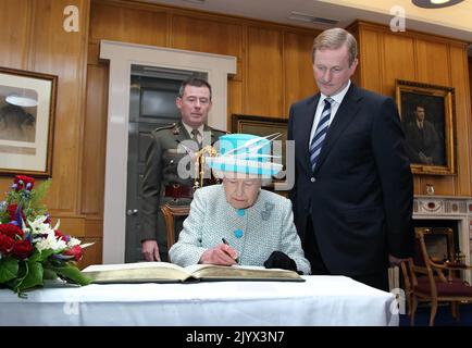 Aktenfoto vom 18/05/2011 von Königin Elizabeth II., die das Besucherbuch unterschrieb, während Taoiseach Enda Kenny am zweiten Tag ihres Staatsbesuches in Irland Regierungsgebäude in Dublin ansieht. Wie Buckingham Palace mitteilte, starb die Königin heute Nachmittag friedlich in Balmoral. Ausgabedatum: Donnerstag, 8. September 2022. Stockfoto